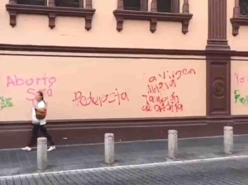 Encapuchadas grafitean edificios durante marcha contra violencia