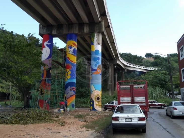 Acayuqueño pinta murales en columnas de puente en Coatzacoalcos