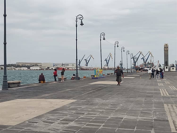 Personas contemplan norte en el malecón de Veracruz