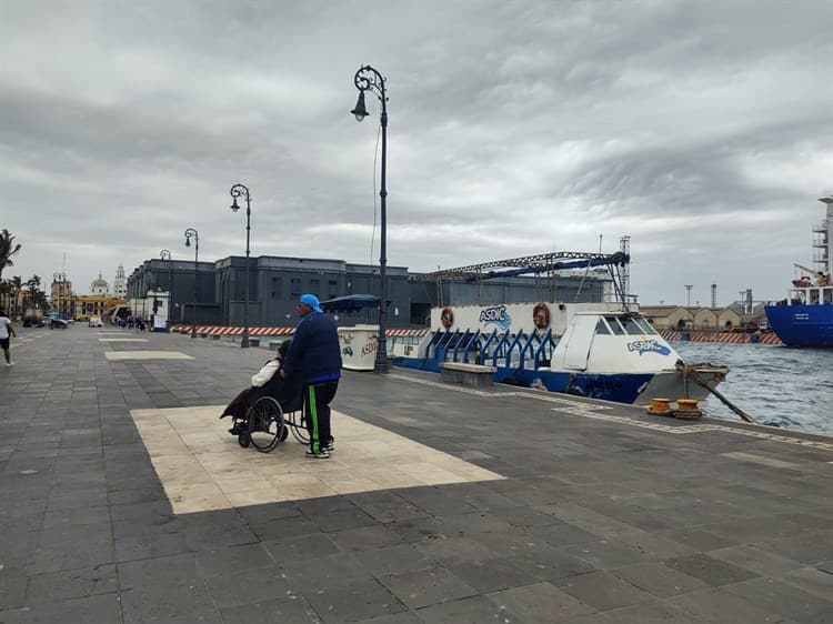 Personas contemplan norte en el malecón de Veracruz