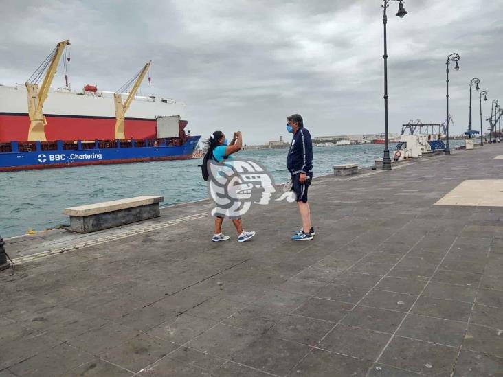 Personas contemplan norte en el malecón de Veracruz