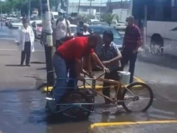 Hombre en triciclo salva a peatones del agua, en Veracruz