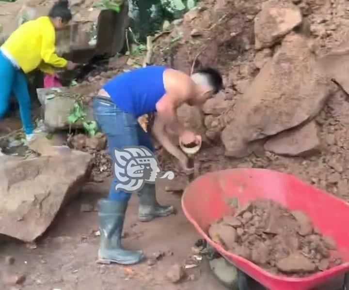 Ante la falta de apoyo, habitantes de Yecuatla retiran piedras y lodo de un deslave (+Video)