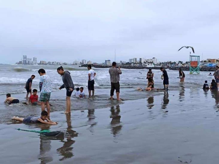 Turistas disfrutan la playa de Veracruz con todo y frío