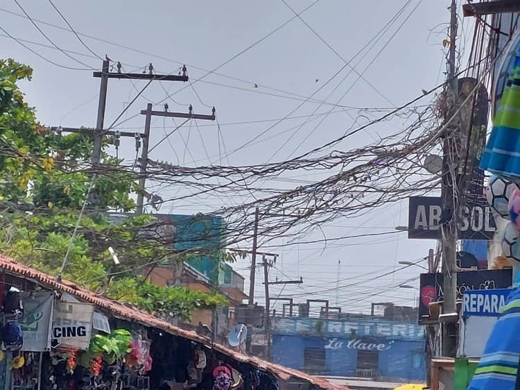 Comerciantes piden quitar “telarañas” en calles de Veracruz; temen descarga eléctrica