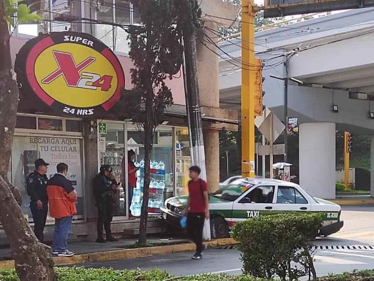 Taxi se sube a banqueta en Xalapa, y choca contra señalética