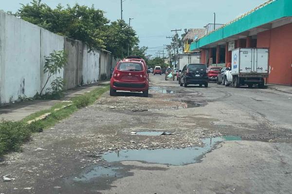 Baches y acumulación de agua por lluvias, un obstáculo para atravesar la avenida Icazo, en Veracruz