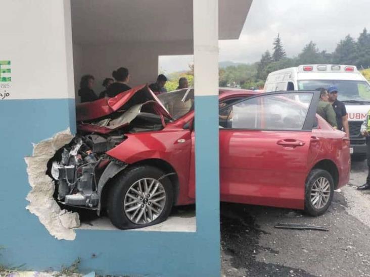 Chocan autos en Acajete; uno término incrustado en parada de autobús