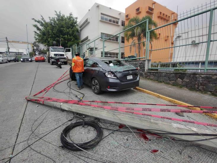 Grúa derriba poste en Xalapa y karma cae sobre auto del dueño